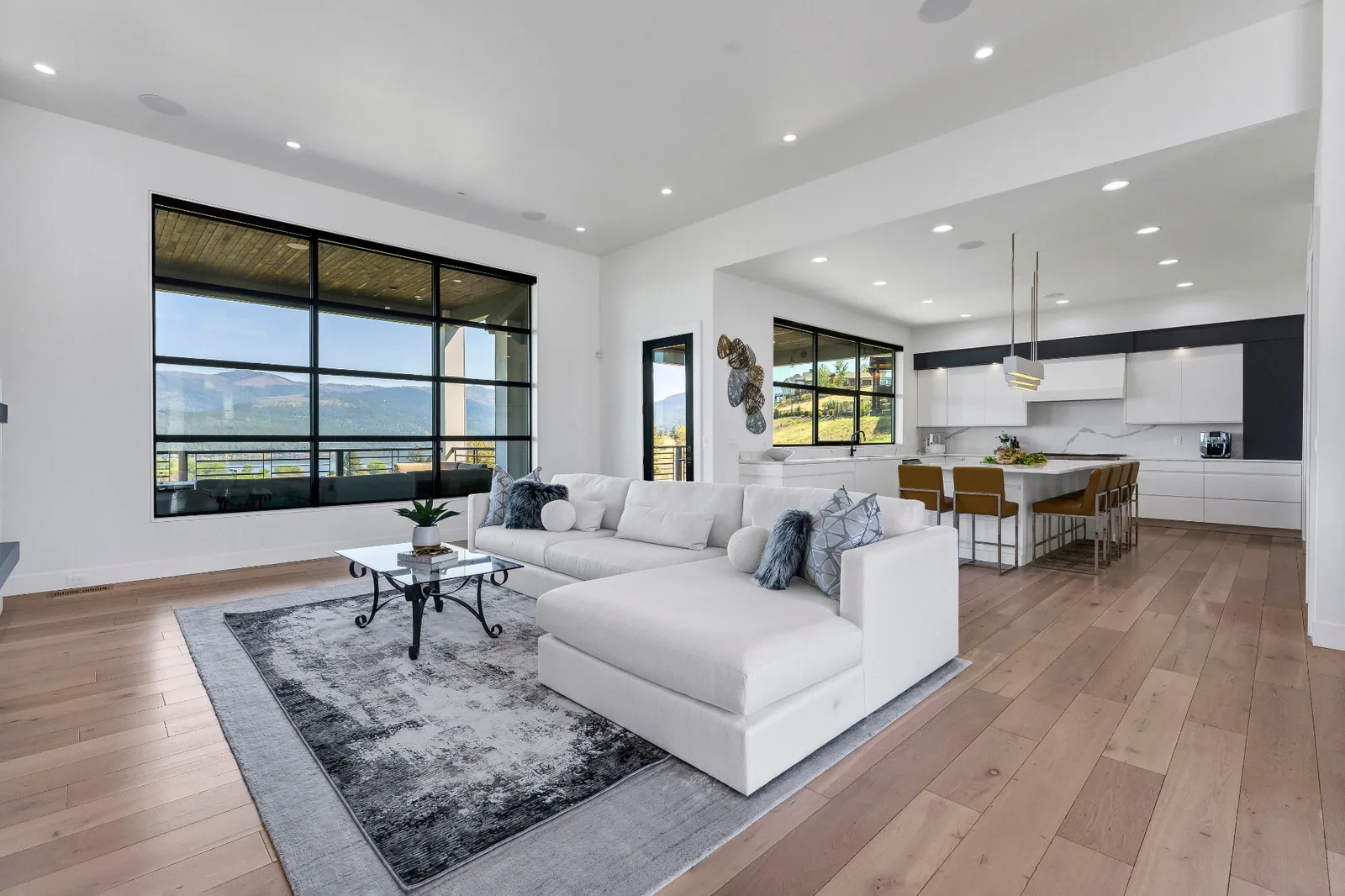 Great room sectional with mountain view windows opening to the kitchen
