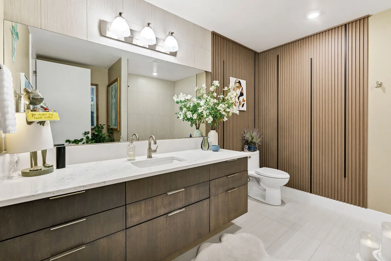 Bath with quartz vanity, wide mirror and fluted wood wall
