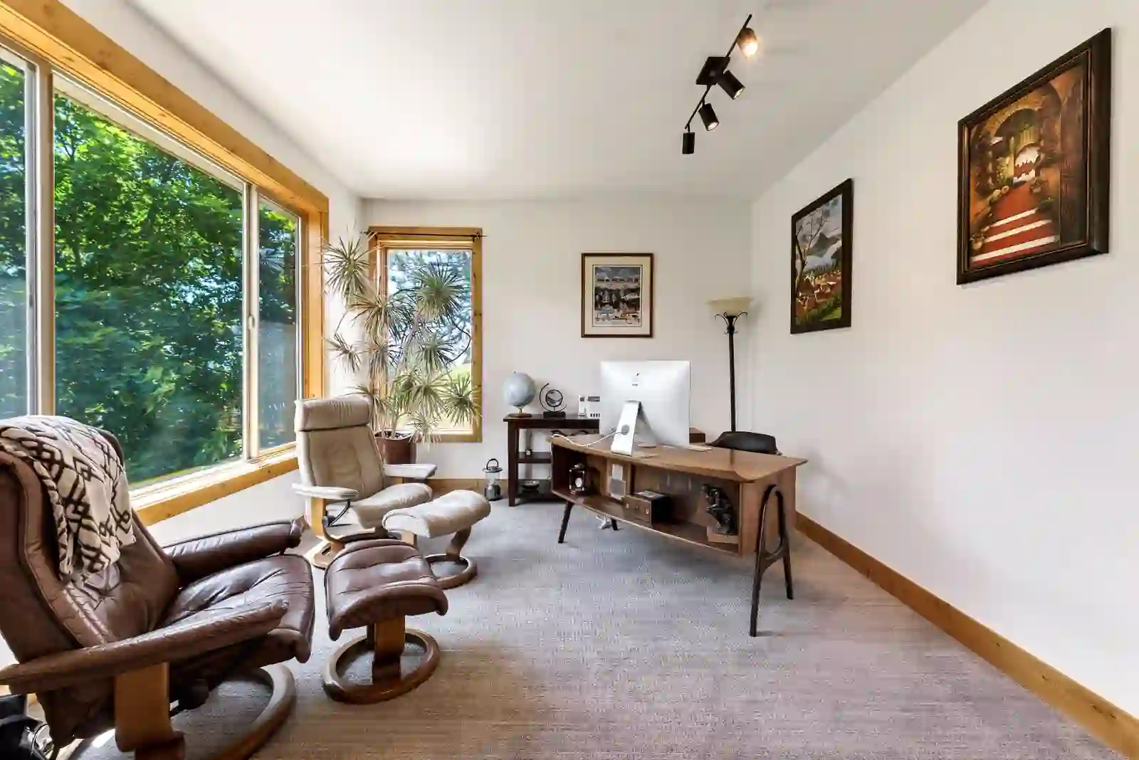 Office with vaulted ceiling and large windows looking into the trees