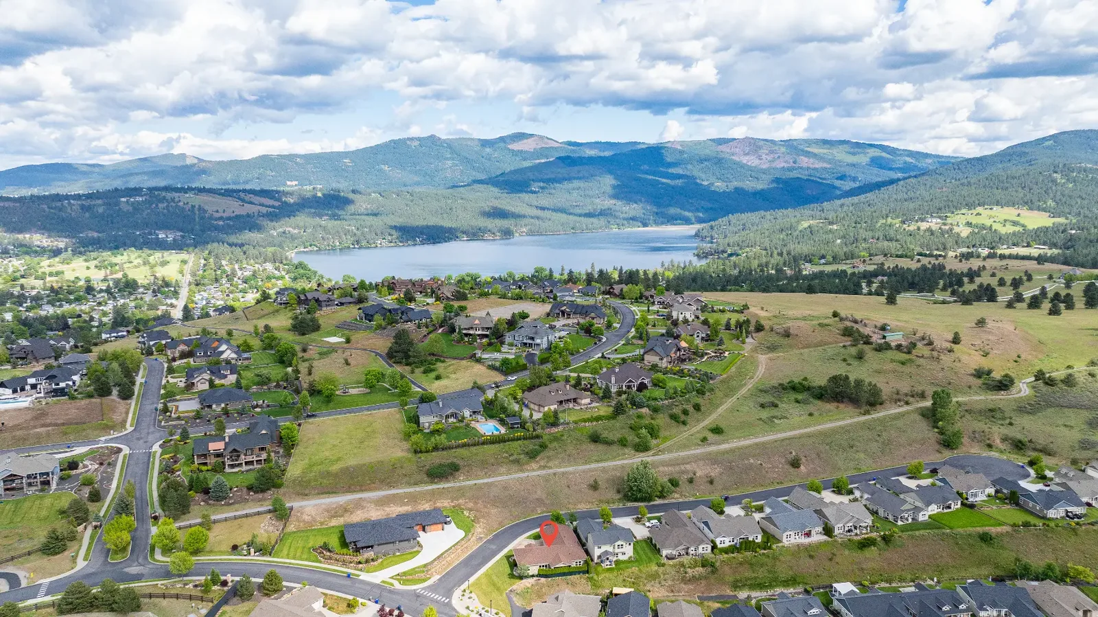 Aerial showing the home's setting above the lake and surrounding mountains