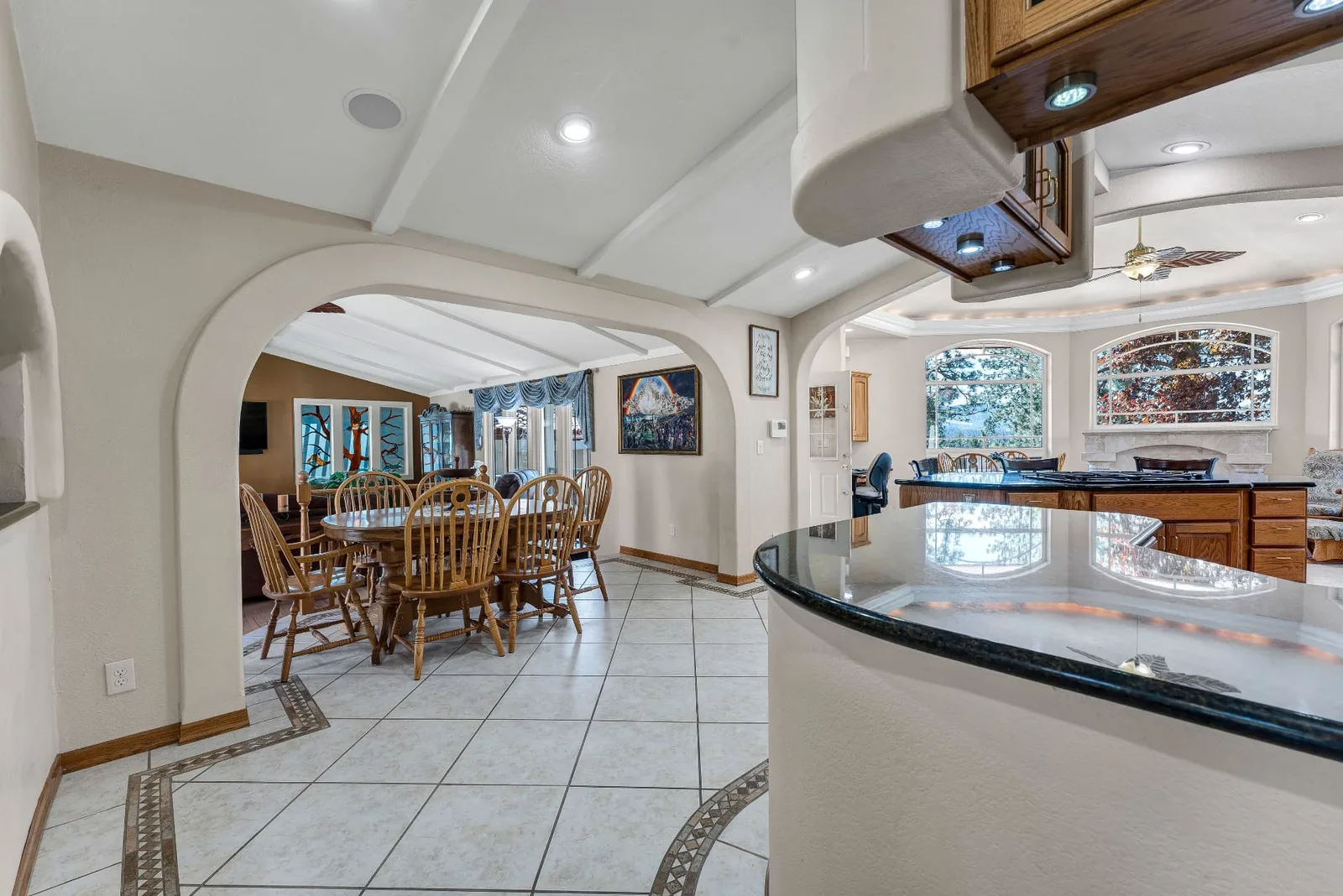 Arched openings connecting the dining area to the kitchen bar and tile floor medallion