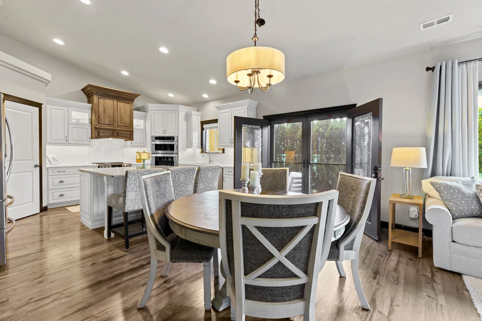 Open dining area with round table opening to the kitchen and patio doors