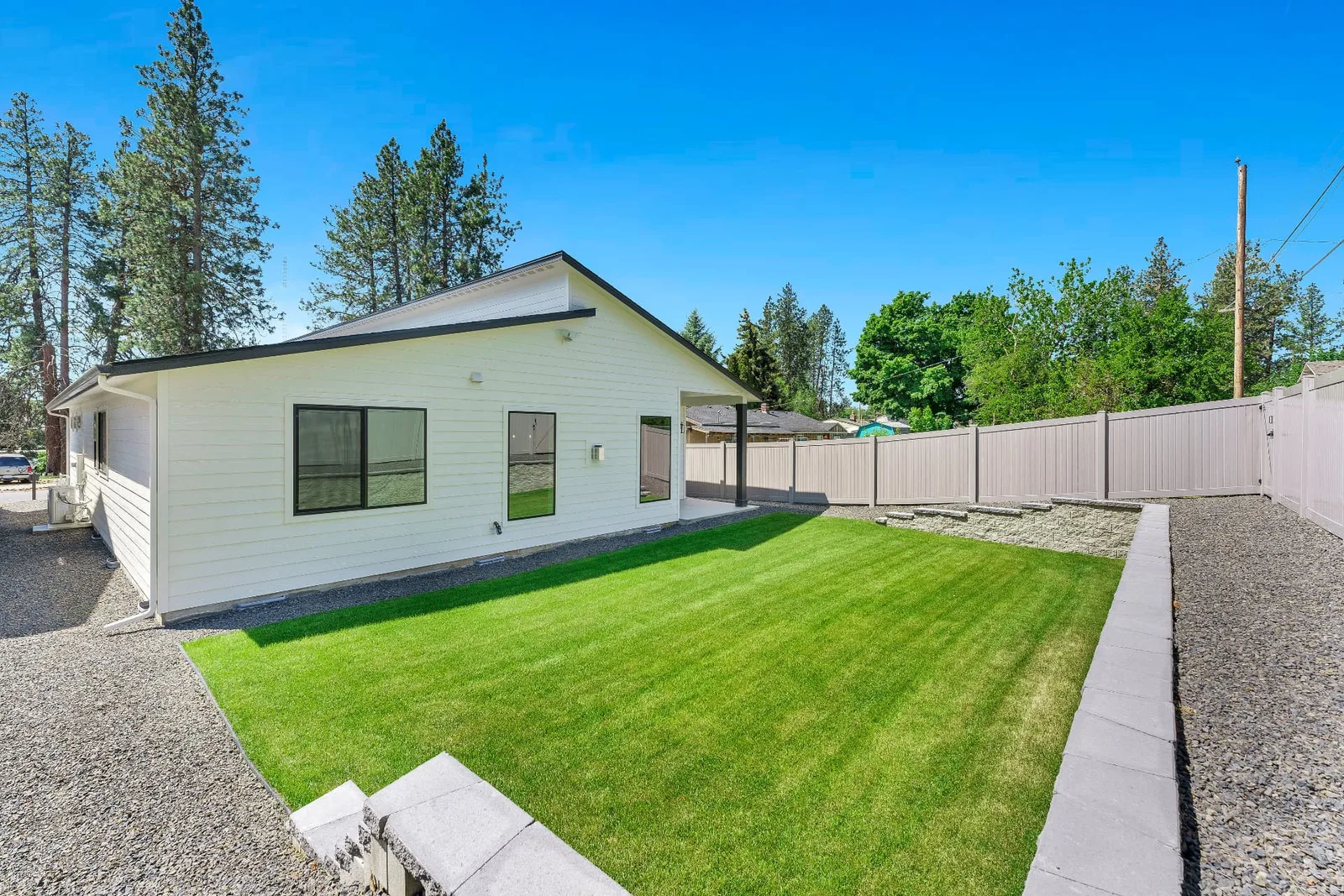 Backyard with covered patio, fresh lawn and fully fenced perimeter