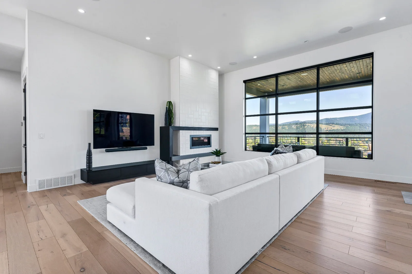 Living room with linear fireplace and floor-to-ceiling window to the hills