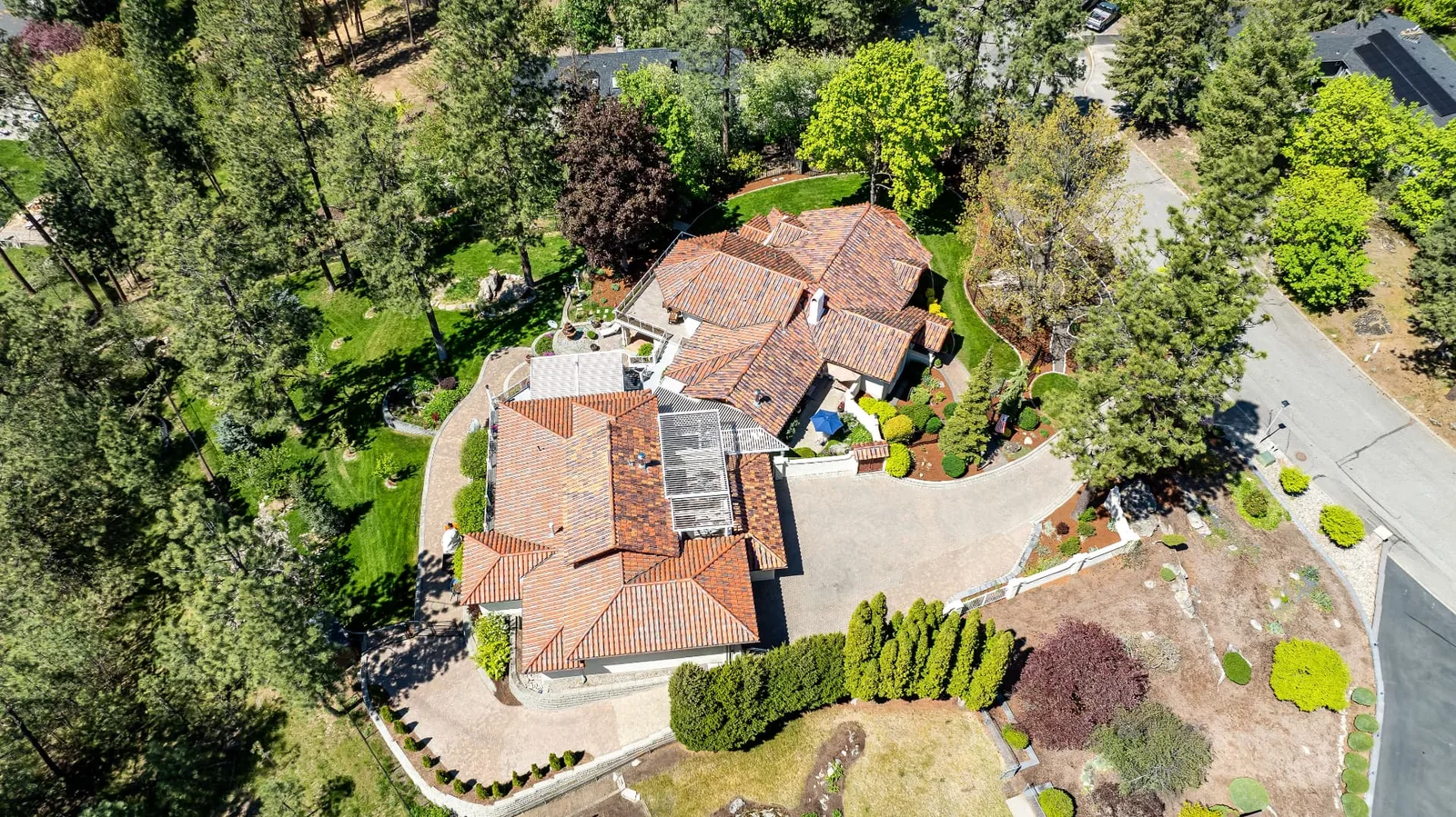 Overhead aerial of the tile-roofed estate at 15918 E Cameron Ct with paver drive and terraced gardens