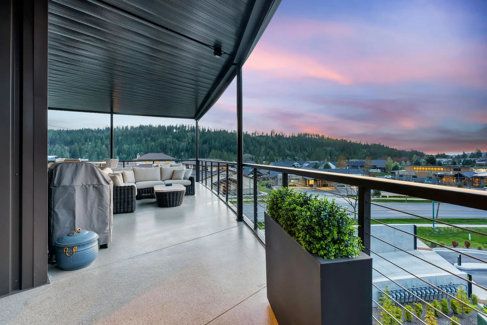 Covered patio with outdoor seating overlooking the RiverStone district at sunset